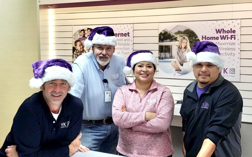 Employees pose in Christmas hats